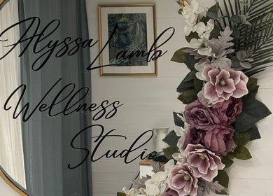 Elegant wall decor at Alyssa Lamb Wellness Studio, Dunfermline, Scotland, GB. Beautiful florals beside a round mirror.