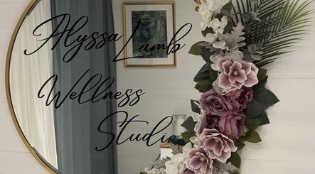 Elegant wall decor at Alyssa Lamb Wellness Studio, Dunfermline, Scotland, GB. Beautiful florals beside a round mirror.