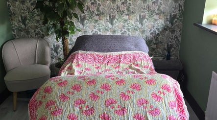 Tranquil therapy room at Lauren Louise Wellness, Biggleswade, England, GB with cozy chair and floral decor.
