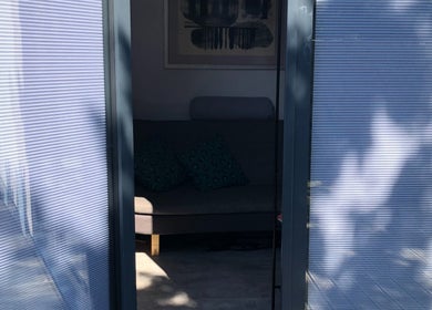 Relaxing sofa area at Emma Bateman Reflexology, York, England, GB, viewed through a sunlit window.