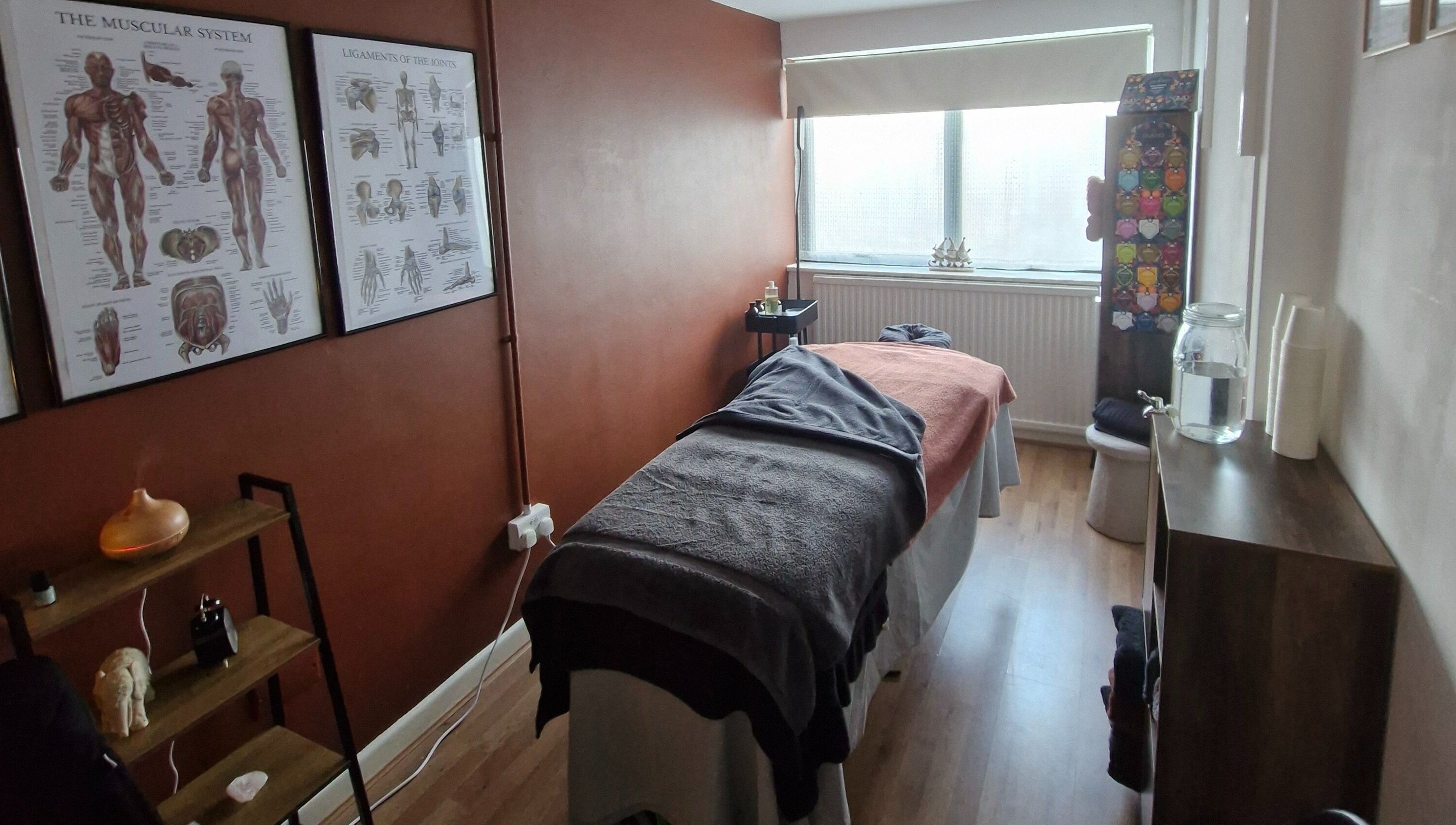 Relaxing treatment room at MORGAN SPA in Gloucester, England, GB, features massage table and anatomical decor.