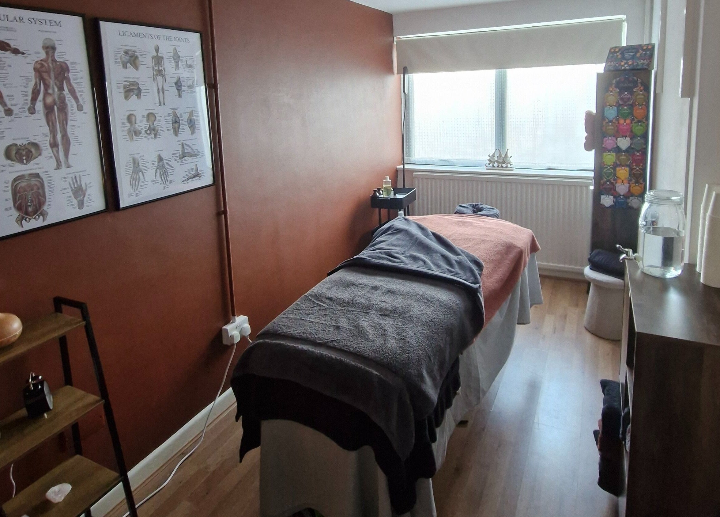 Relaxing treatment room at MORGAN SPA in Gloucester, England, GB, features massage table and anatomical decor.