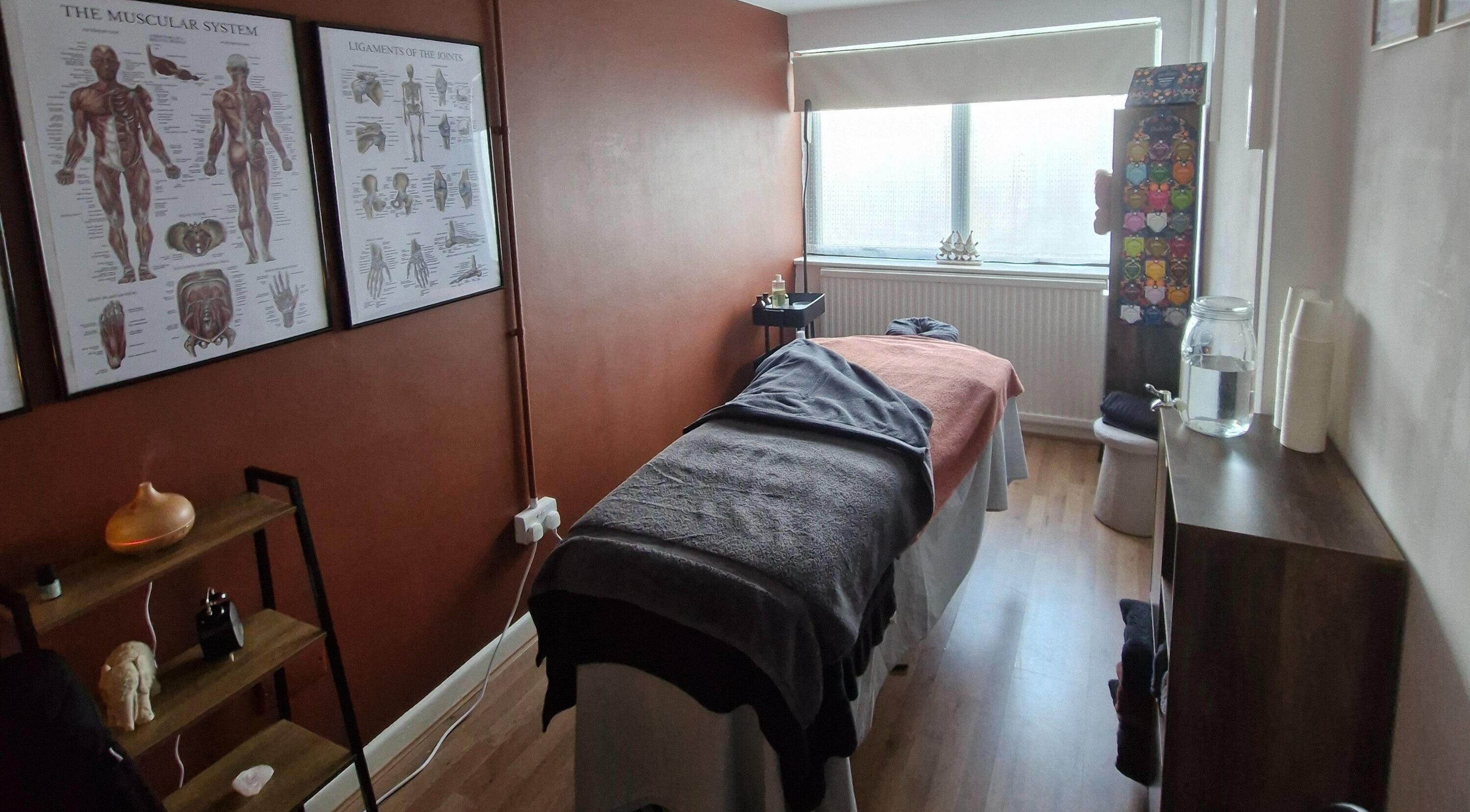 Relaxing treatment room at MORGAN SPA in Gloucester, England, GB, features massage table and anatomical decor.