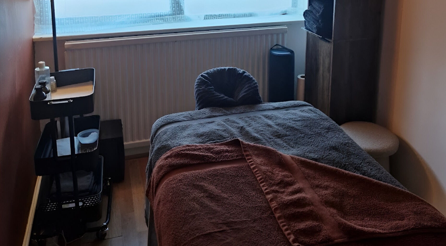 Massage room at MORGAN SPA in Gloucester, England, GB, featuring a cozy massage table with soft lighting.