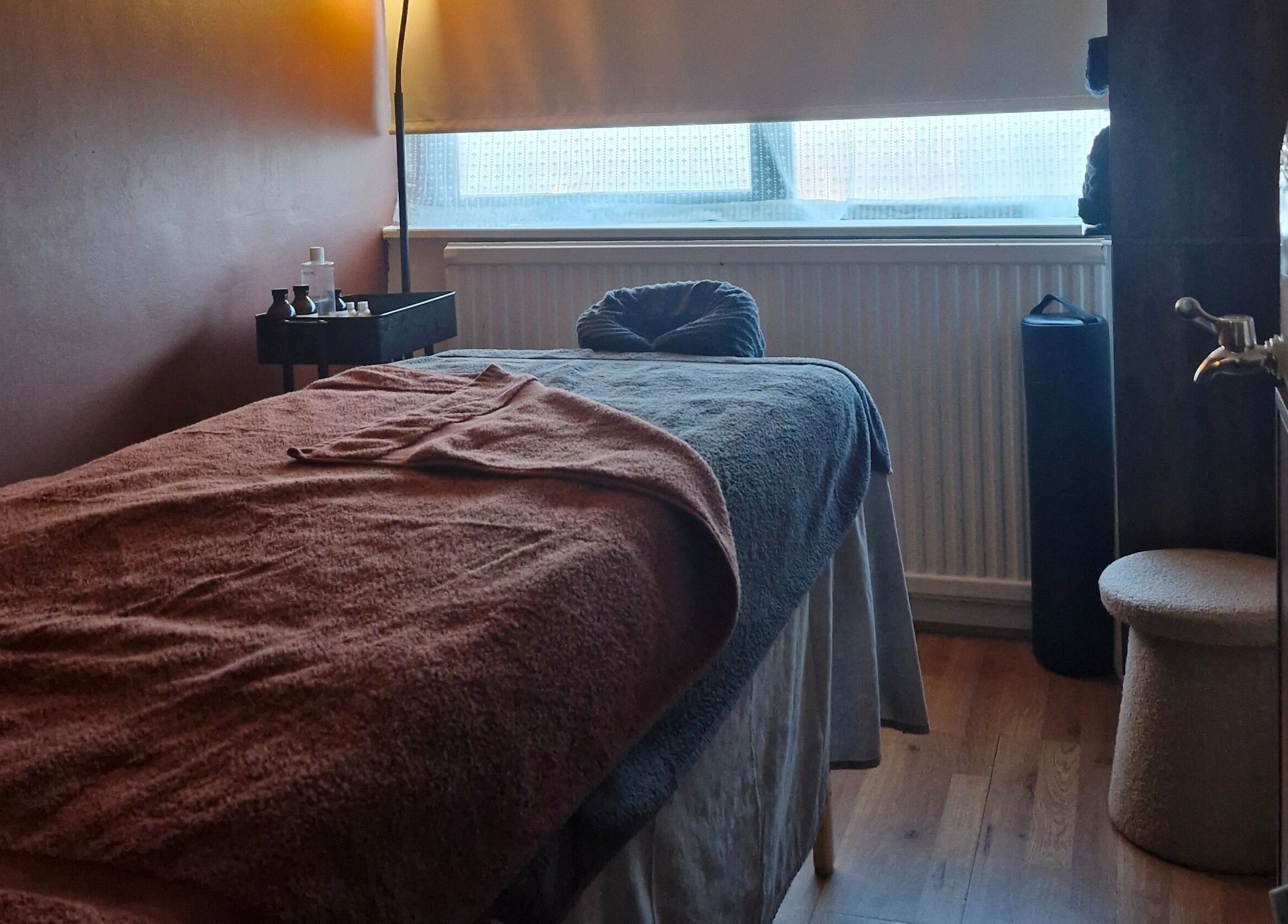 Relaxing massage room at MORGAN SPA, Gloucester, England, GB, with a cozy treatment bed and warm lighting.