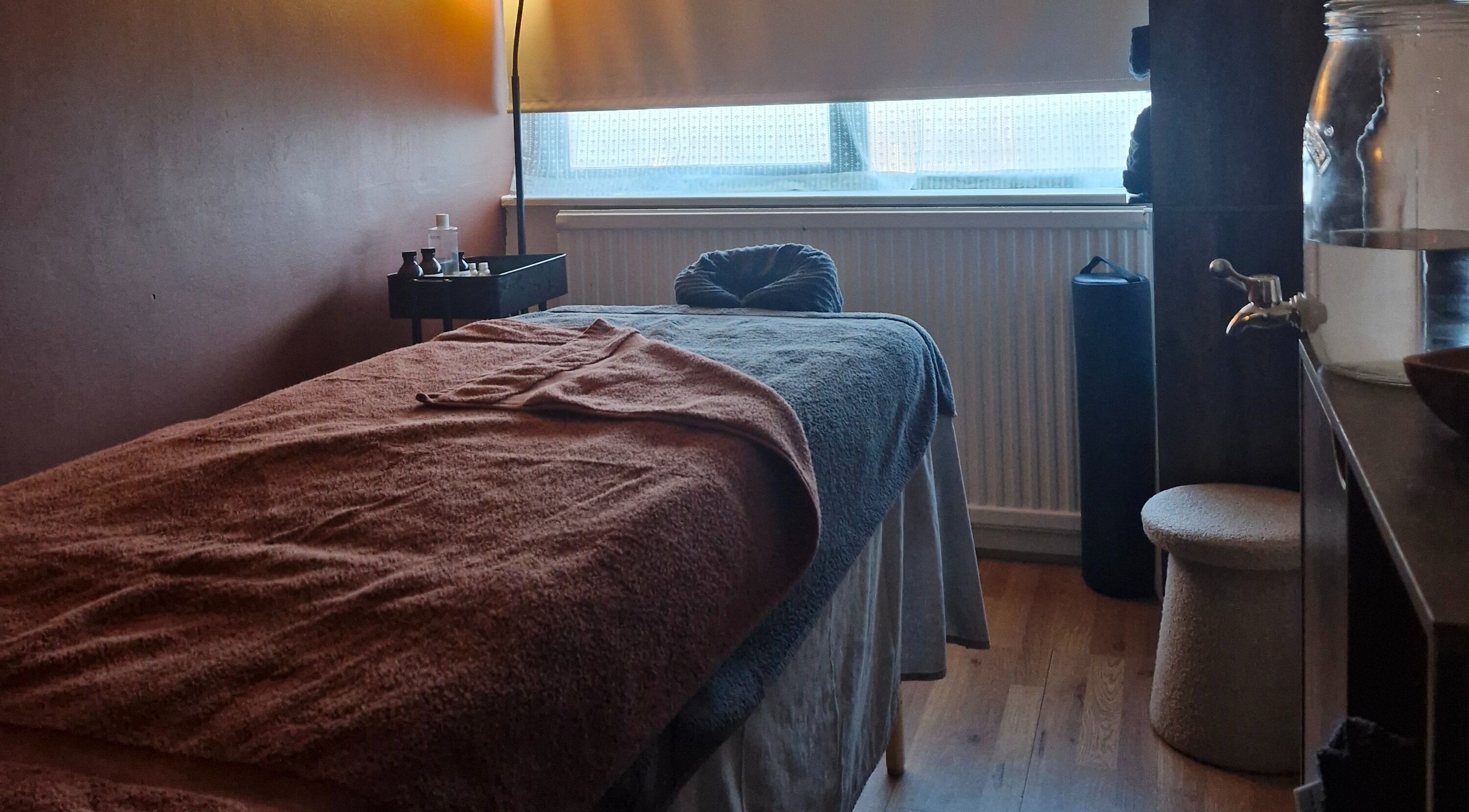 Relaxing massage room at MORGAN SPA, Gloucester, England, GB, with a cozy treatment bed and warm lighting.