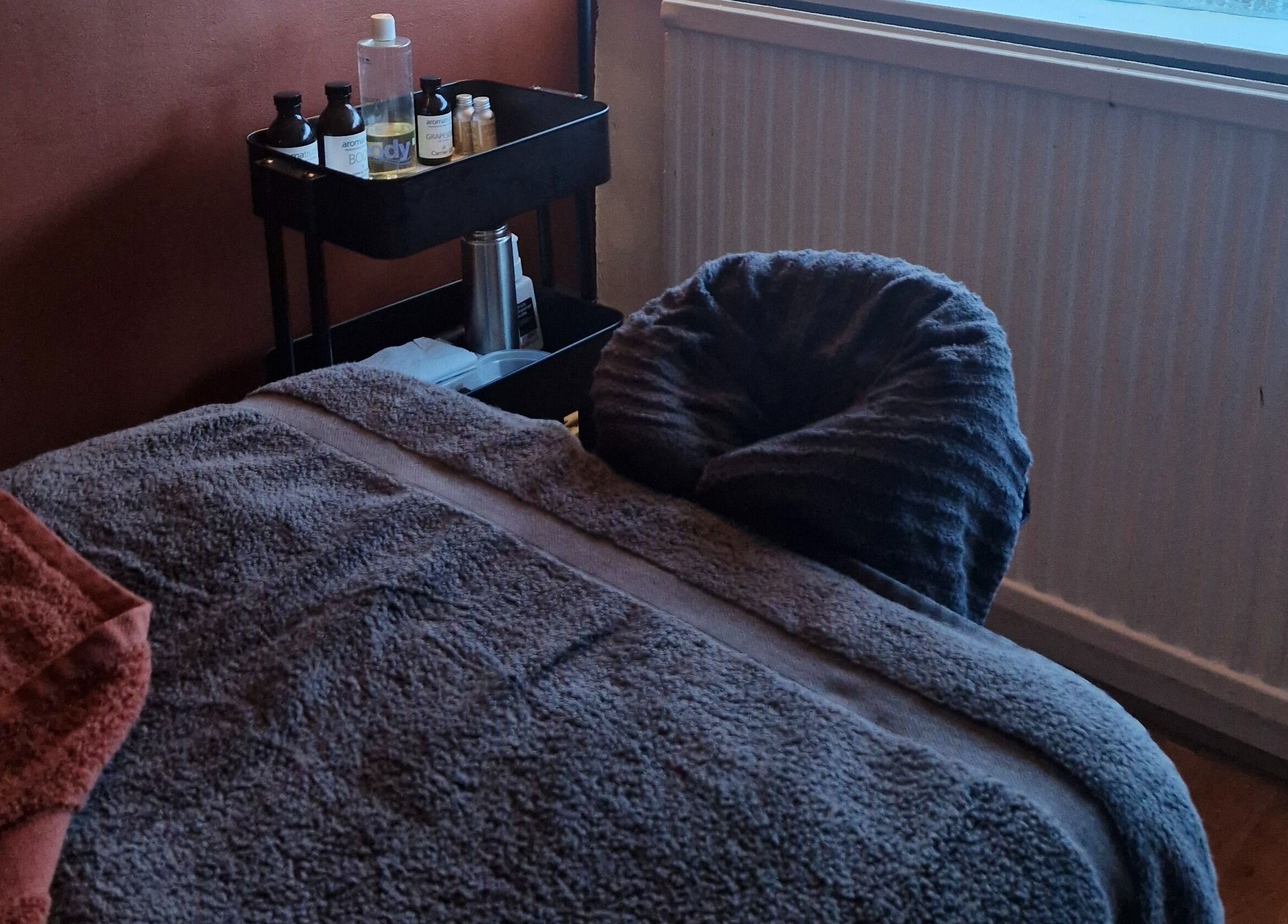 Relaxing spa treatment room at MORGAN SPA, Gloucester, England, GB with towels and skincare products.