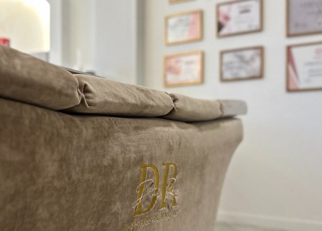 Κομψός καναπές στο Divine Room Lash & Brow Studio, Βέροια, GR με πιστοποιητικά στον τοίχο.