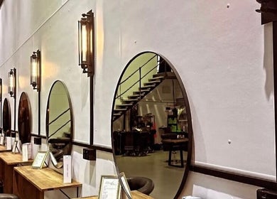 Elegant salon setup at Fanny’s Barber in Rothwell, Queensland, AU featuring stylish mirrors and comfortable seating.