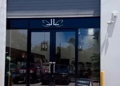 Entrance to Fanny’s Barber in Rothwell, Queensland, AU, featuring sleek glass doors.