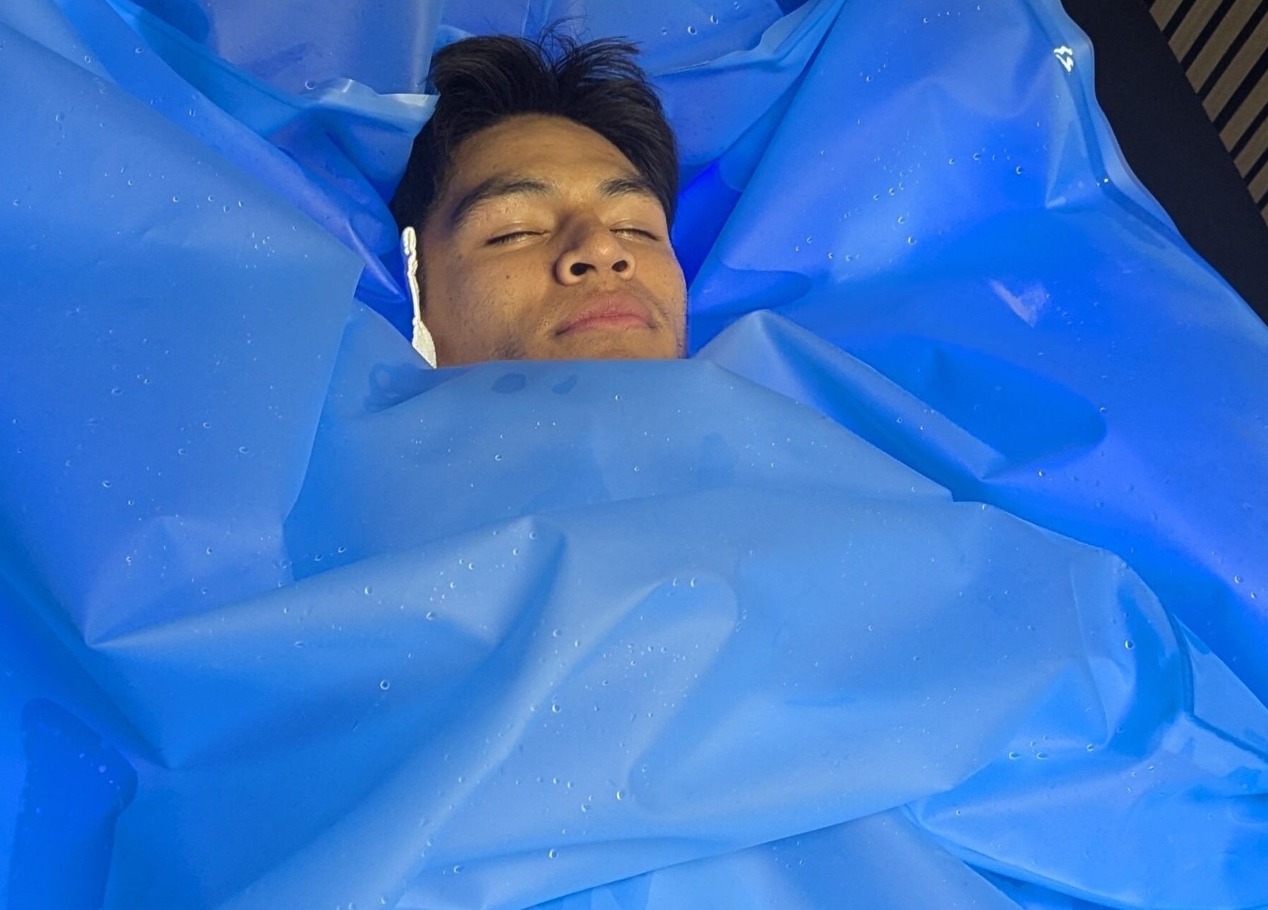 Relaxation therapy at The Zone in Coeur d'Alene, Idaho, US, featuring a person enveloped in a blue wrap.