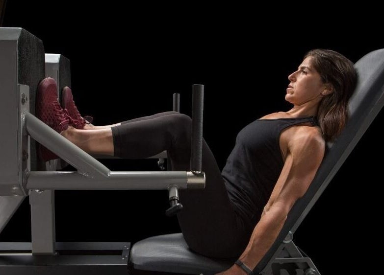 Woman using leg press at The Zone, Coeur d'Alene, Idaho, US for a fitness session.