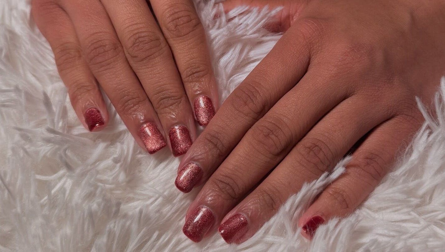 Stylish rose-colored manicure at Glam Tech Tiana, Burnaby, British Columbia, CA on soft white fabric.
