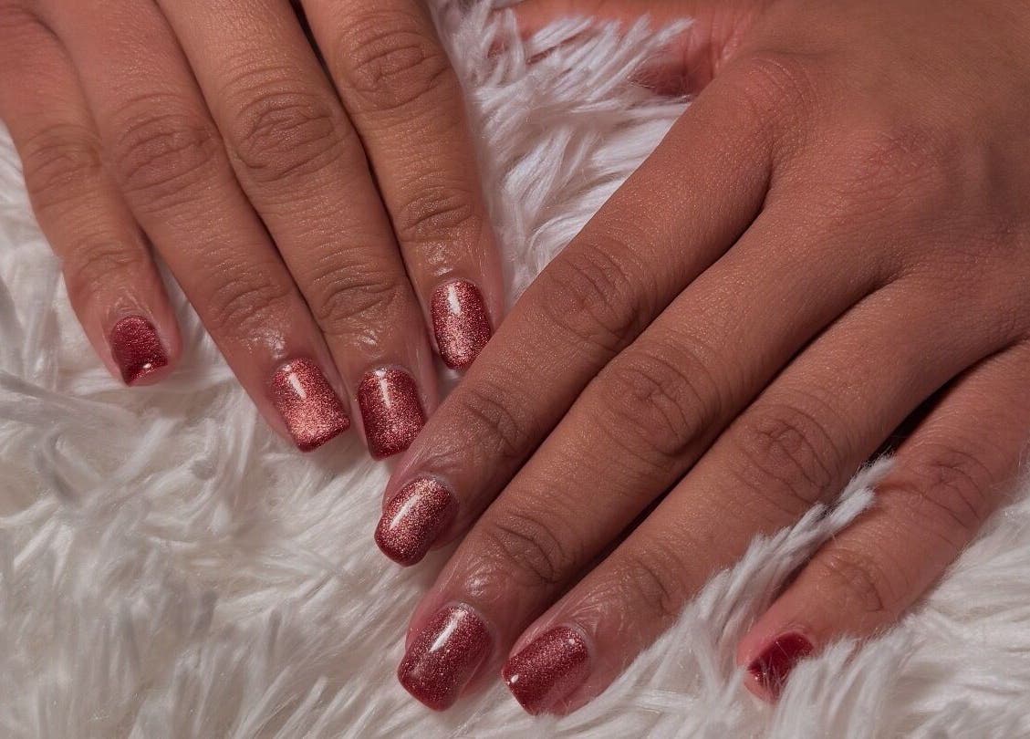 Stylish rose-colored manicure at Glam Tech Tiana, Burnaby, British Columbia, CA on soft white fabric.