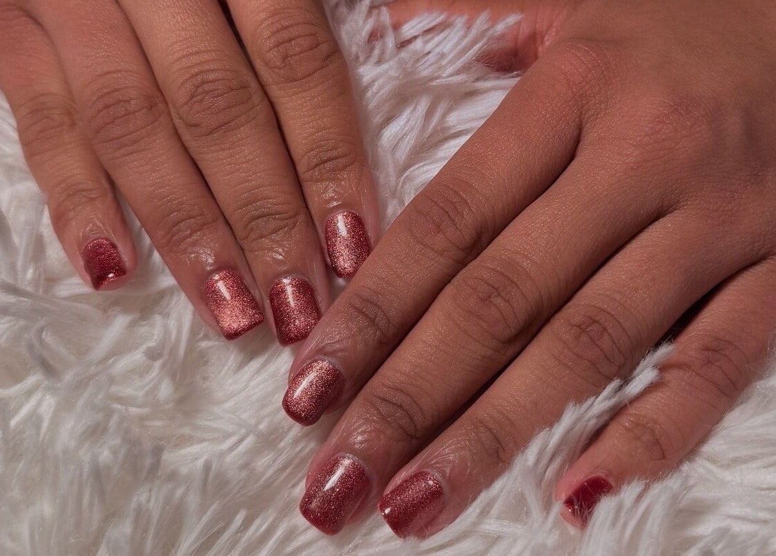Stylish rose-colored manicure at Glam Tech Tiana, Burnaby, British Columbia, CA on soft white fabric.