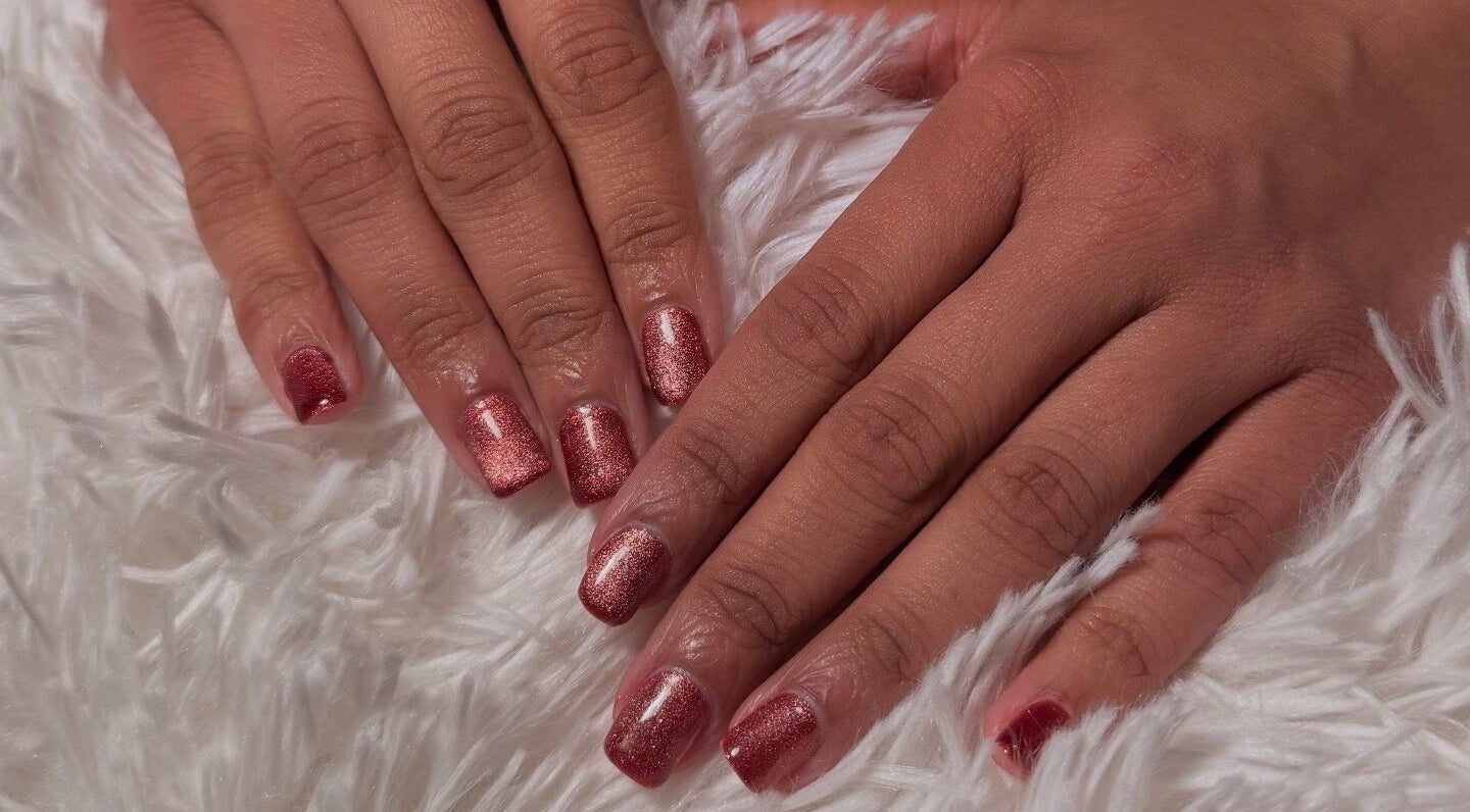 Stylish rose-colored manicure at Glam Tech Tiana, Burnaby, British Columbia, CA on soft white fabric.