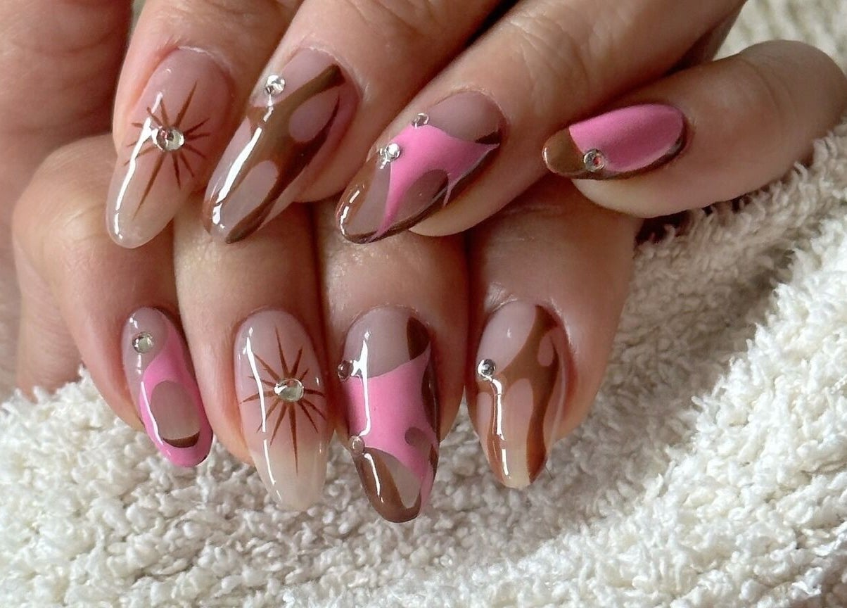 Stylish nail art at Soulsister Nail, Hong Kong Island featuring pink, brown, and rhinestones on elegant hands.