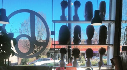 Stylish wigs on display at Jo Hair Studio Vancouver, Vancouver, British Columbia, CA, against a sunlit window.