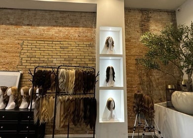 Display of stylish wigs at Jo Hair Studio Toronto, Ontario, CA with exposed brick and greenery.