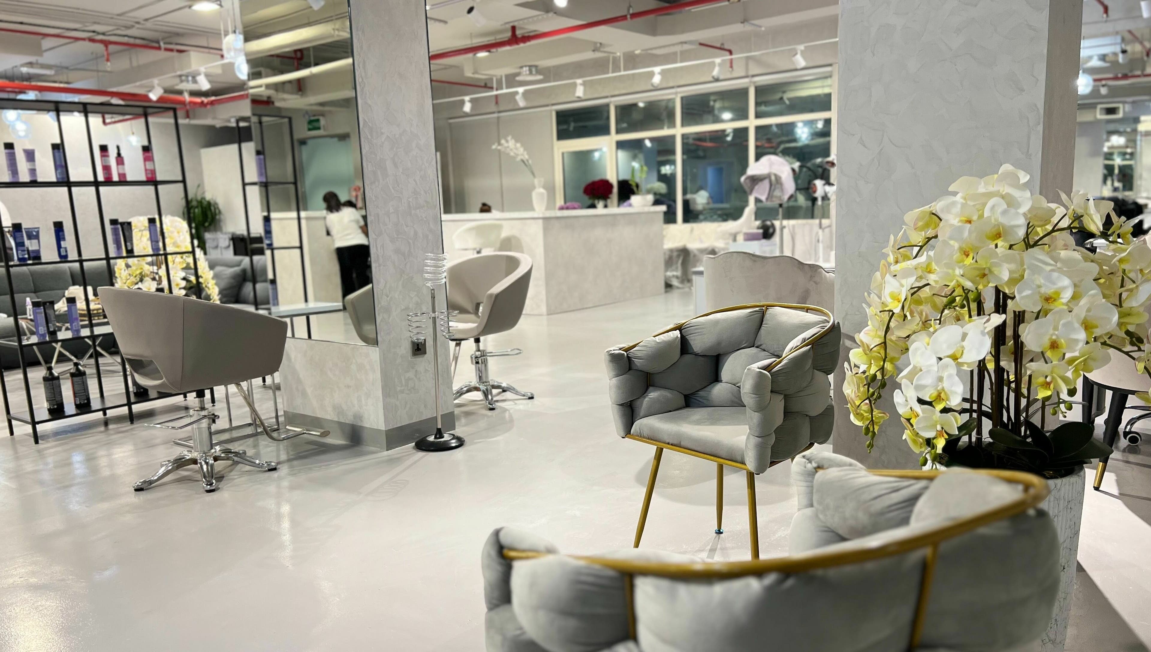 Chic interior of Color Iconic Ladies Salon, Dubai, AE with modern seating and floral decor.