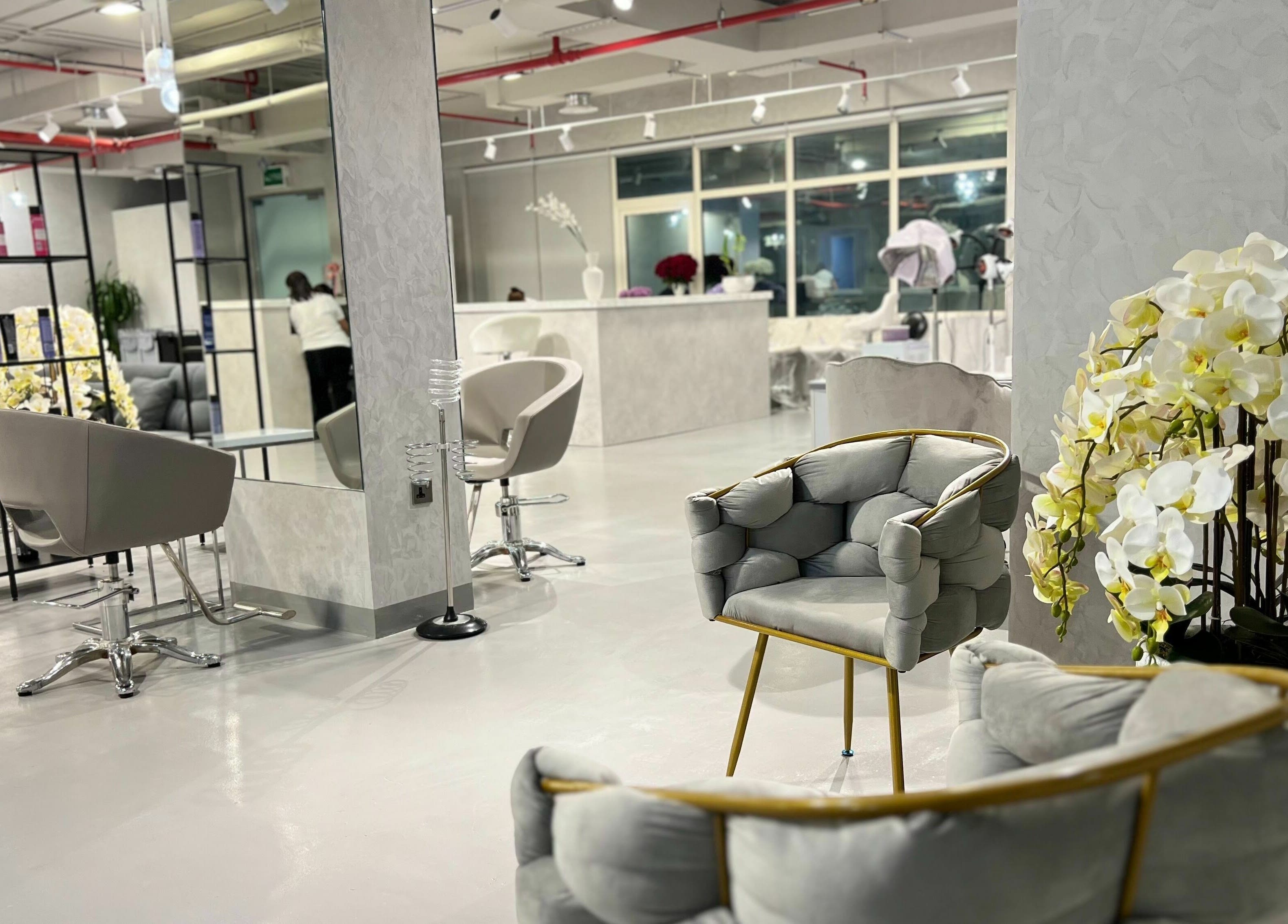 Chic interior of Color Iconic Ladies Salon, Dubai, AE with modern seating and floral decor.