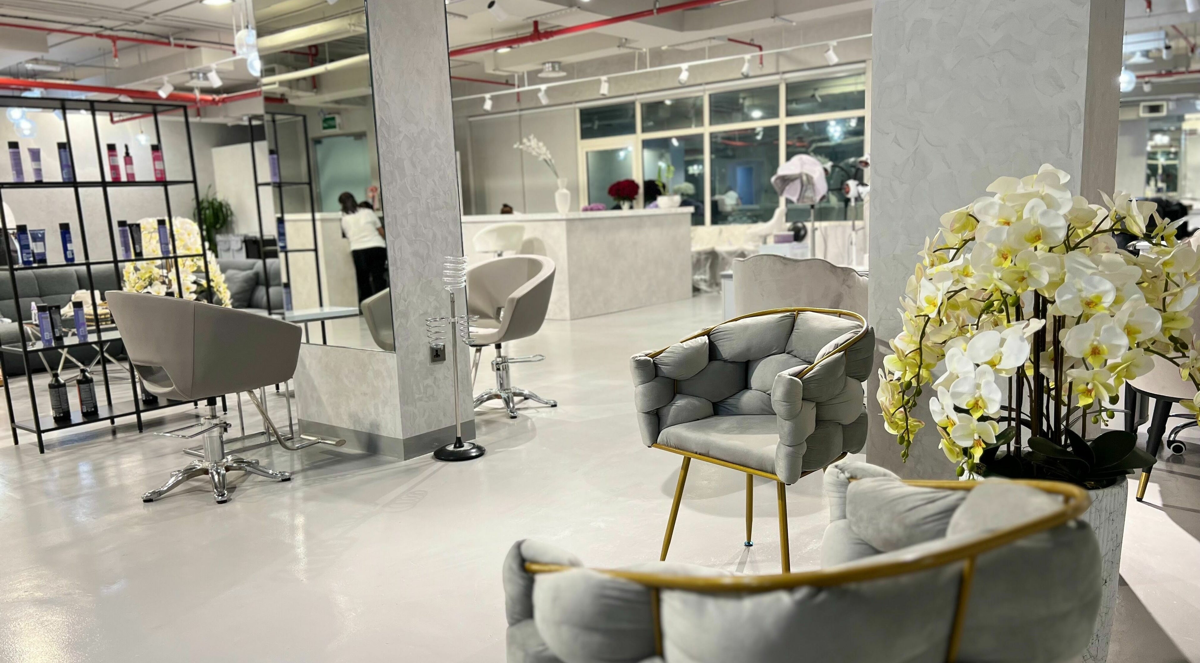 Chic interior of Color Iconic Ladies Salon, Dubai, AE with modern seating and floral decor.