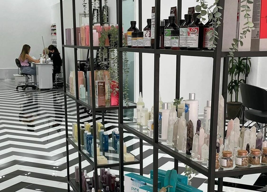 Stylish interior of Color Iconic Ladies Salon in Dubai, AE, featuring product display and nail service.