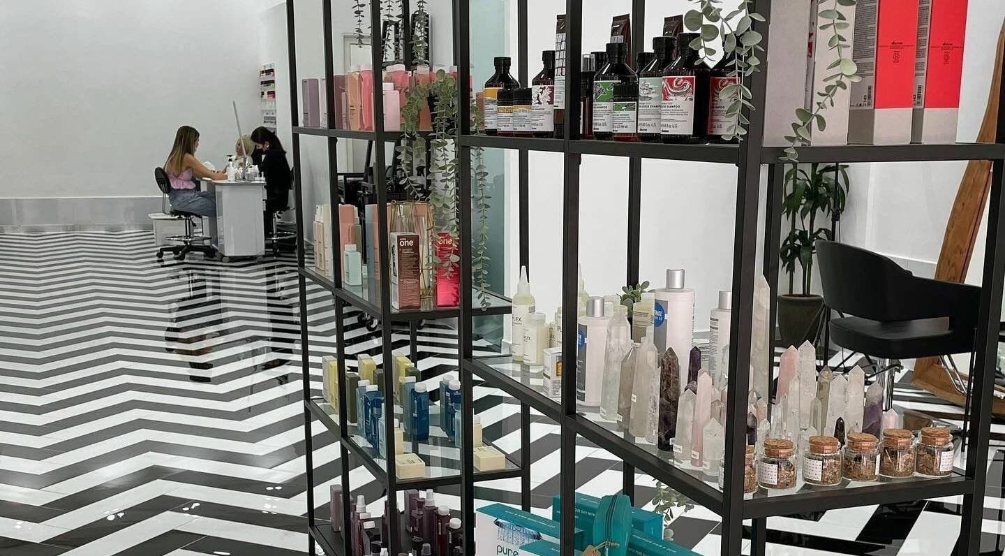 Stylish interior of Color Iconic Ladies Salon in Dubai, AE, featuring product display and nail service.