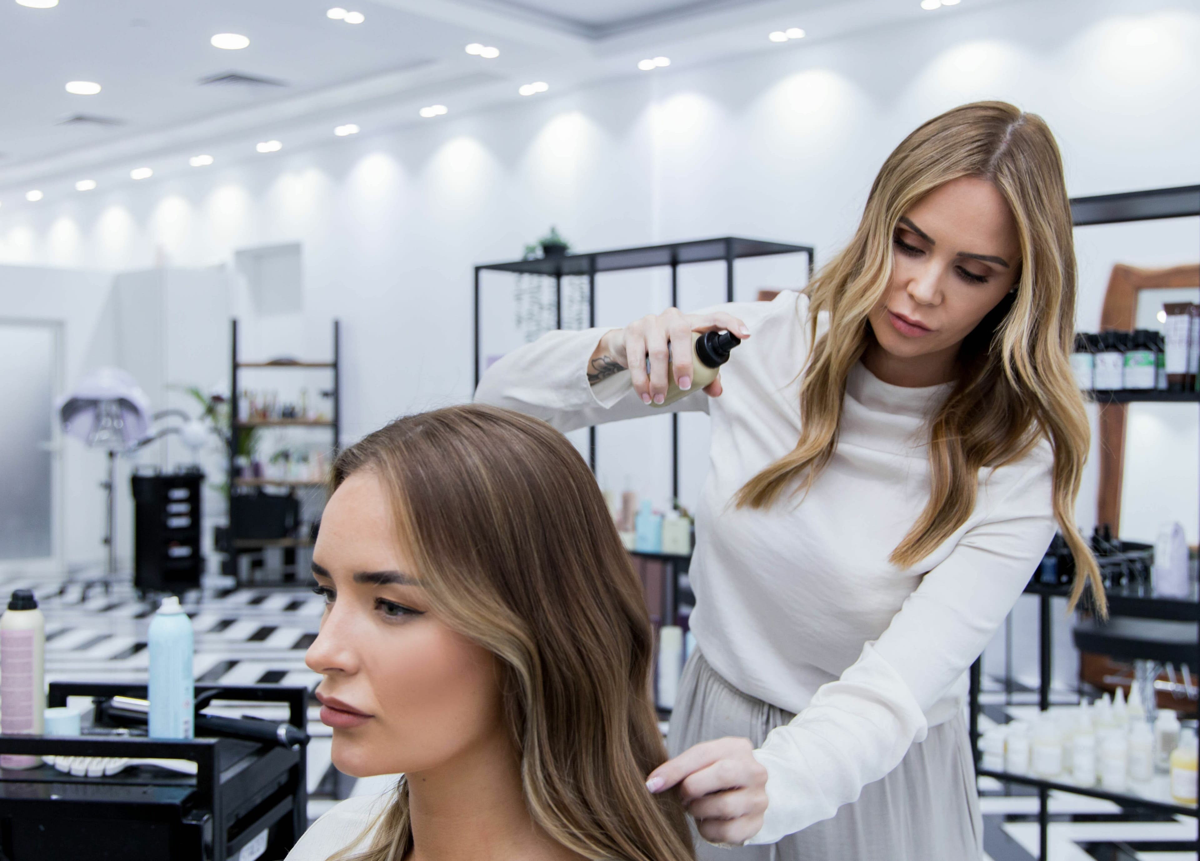Stylist perfecting hair at Color Iconic Ladies Salon, Dubai, AE. Modern salon interior.