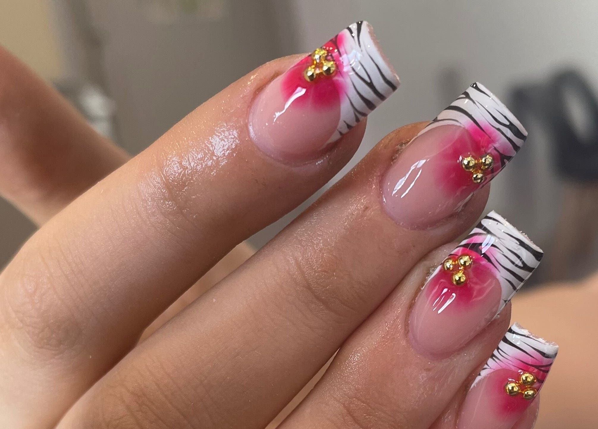 Elegant zebra-striped nails with pink floral accents at Nails by Lilly Brooke, Tenbury Wells, England, GB.