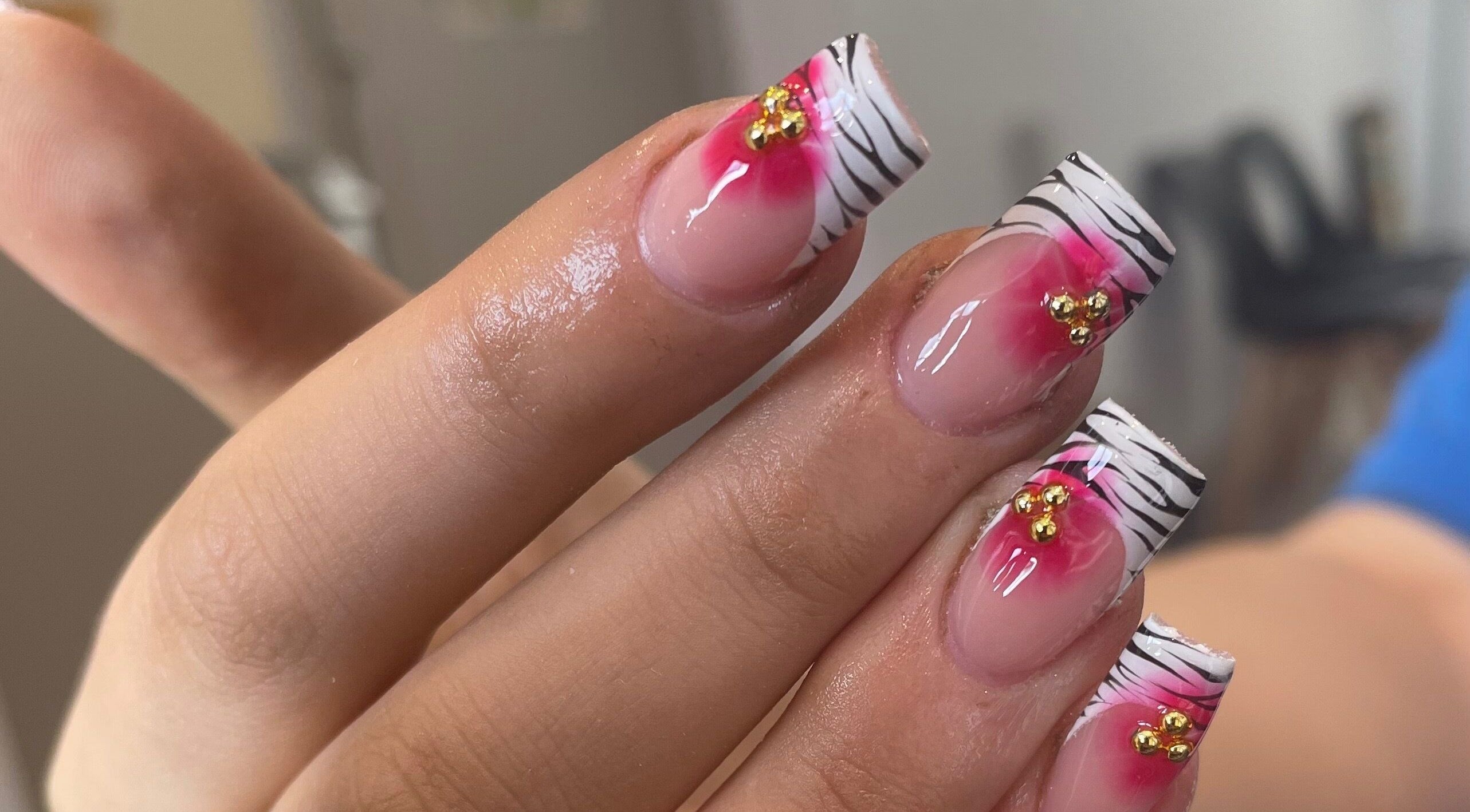 Elegant zebra-striped nails with pink floral accents at Nails by Lilly Brooke, Tenbury Wells, England, GB.