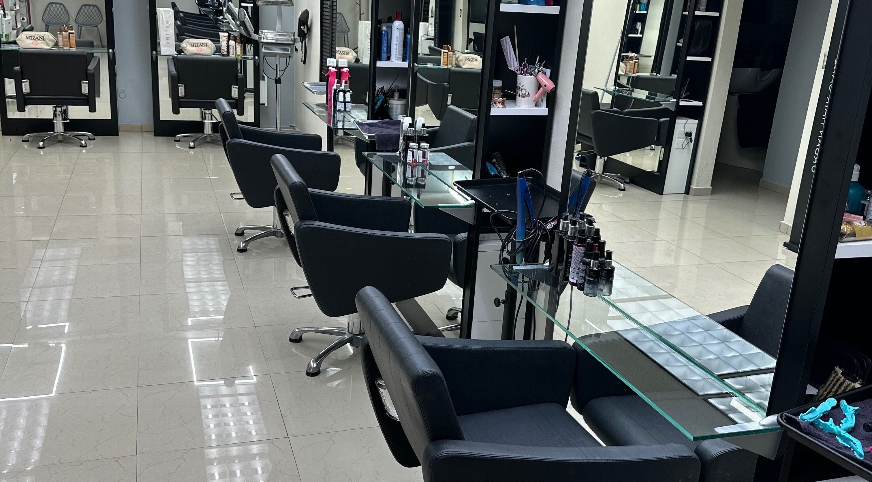 Interior moderno de HR Coiffure Salon en Vega Alta, US, con sillas negras y estaciones bien equipadas.