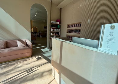 Pose Salon reception area with stylish decor and a cozy pink sofa in Dubai, Dubai, AE.