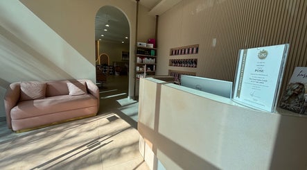 Reception area with a sofa at Pose Salon in Dubai, Dubai, AE, showcasing modern design and comfort.