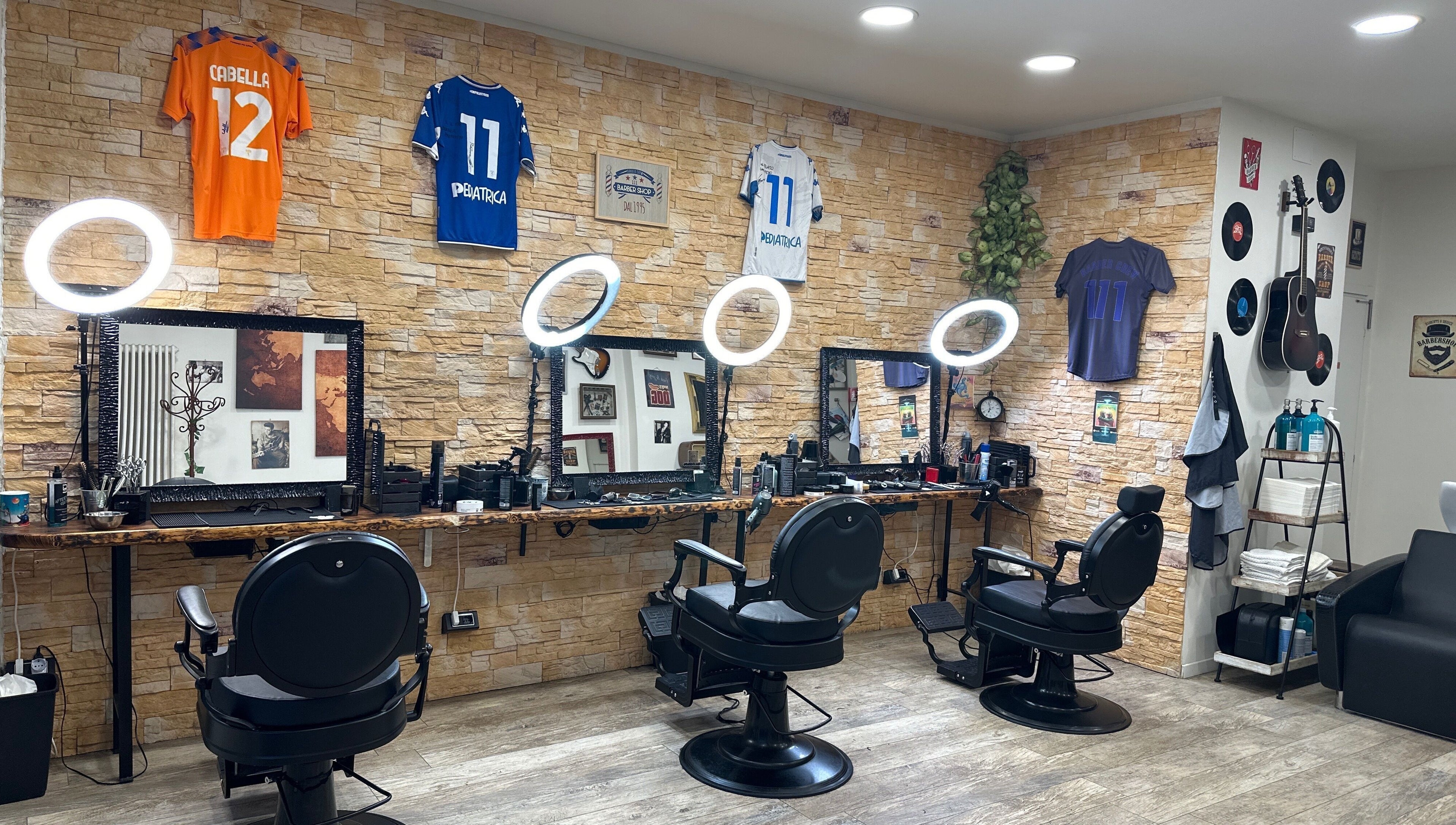 Interno moderno di Barber Crew 111 a Asti, Piemonte, IT con sedie e decorazioni uniche.