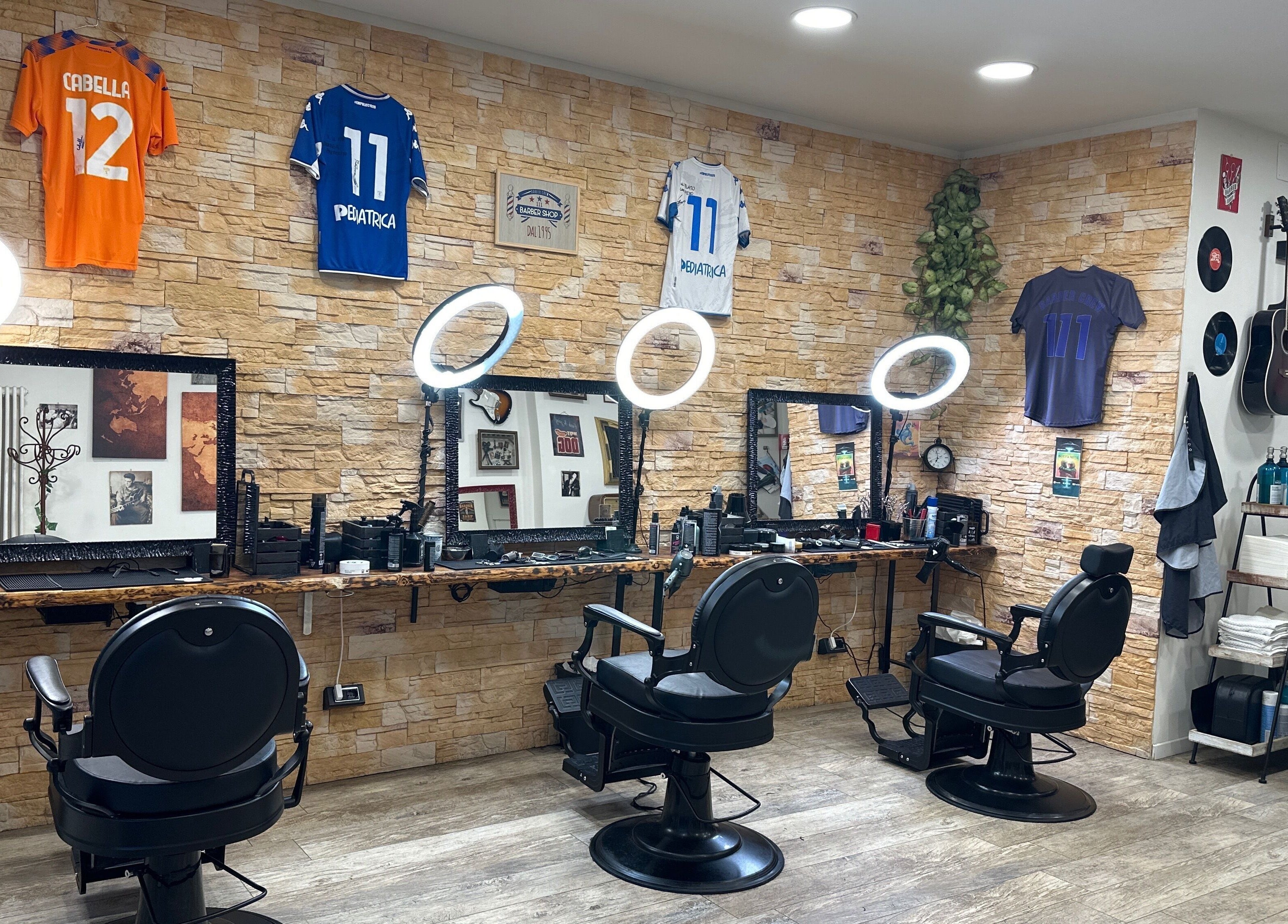 Interno moderno di Barber Crew 111 a Asti, Piemonte, IT con sedie e decorazioni uniche.