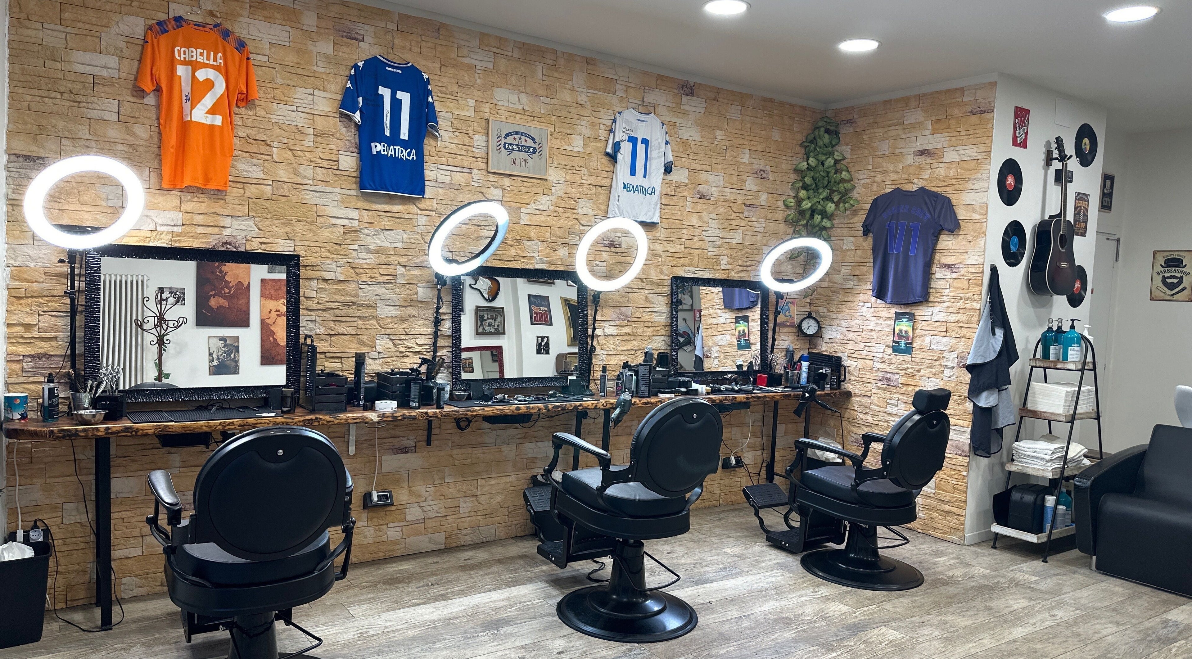 Interno moderno di Barber Crew 111 a Asti, Piemonte, IT con sedie e decorazioni uniche.