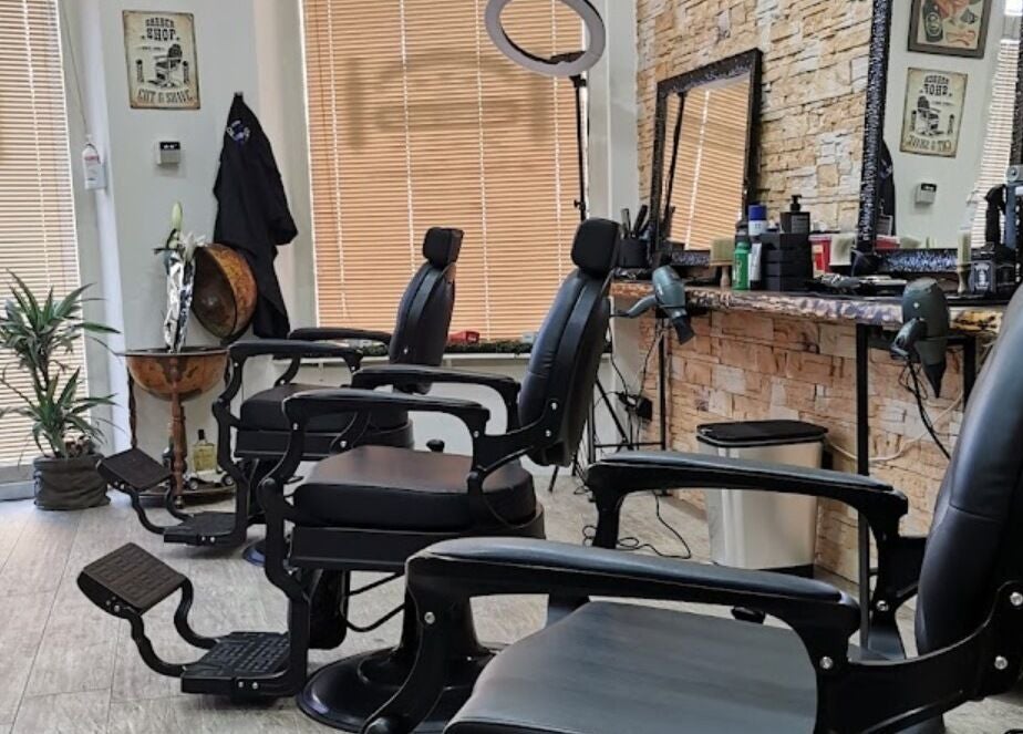 Interno moderno di Barber Crew 111 con sedie eleganti ad Asti, Piemonte, IT.