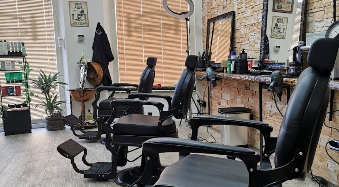 Interno moderno di Barber Crew 111 con sedie eleganti ad Asti, Piemonte, IT.