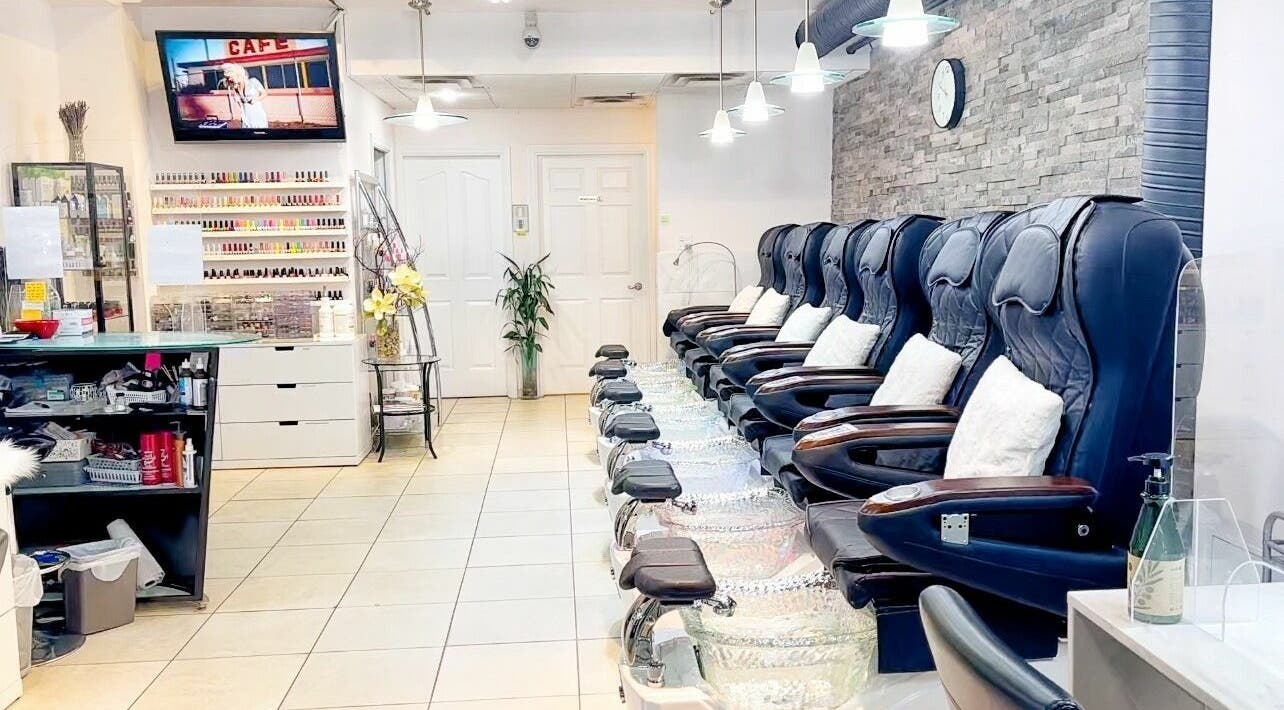 Spacious interior of Posy Nail (Homer St.) in Vancouver, BC, CA with plush spa chairs and vibrant nail polish display.