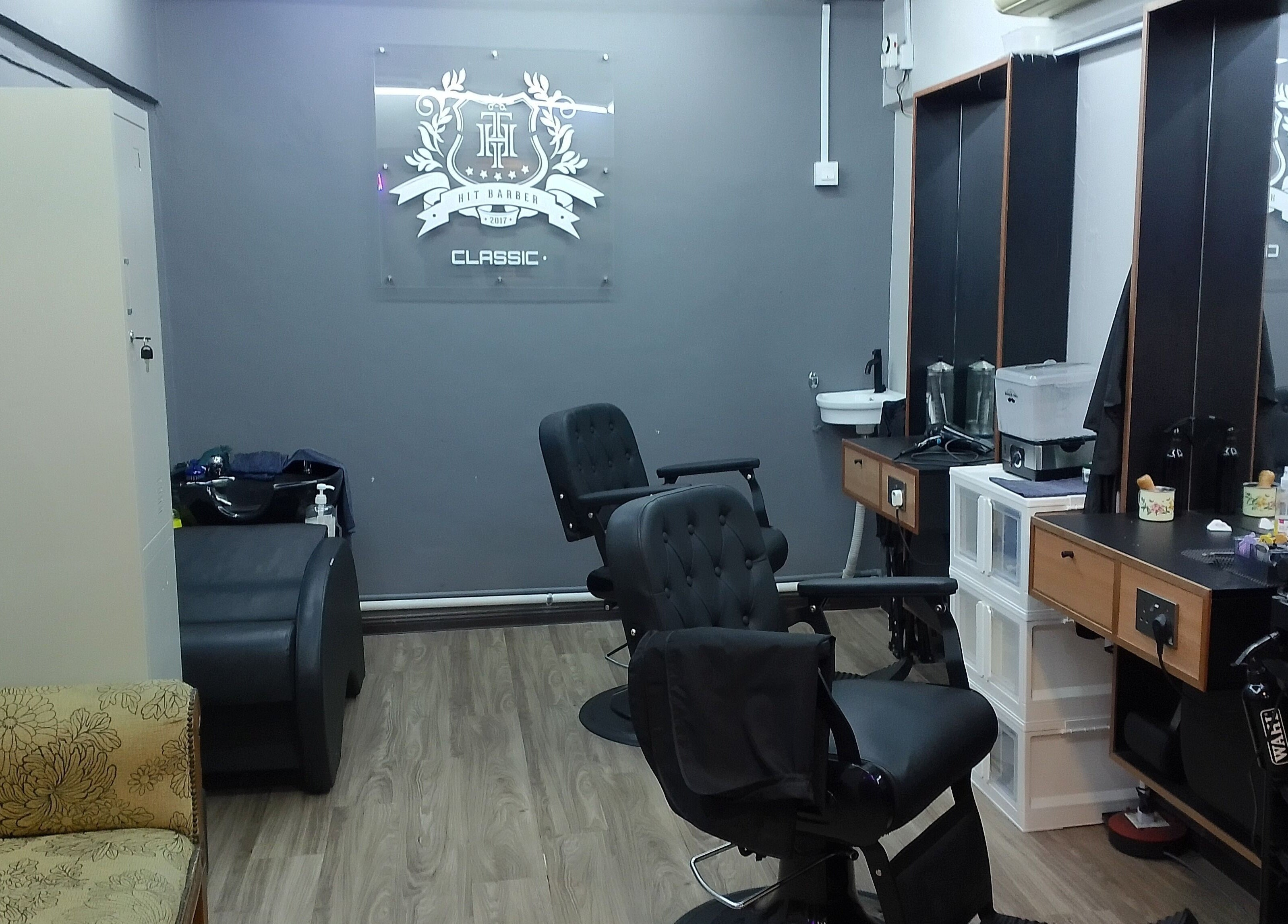 Modern interior of Hit Barber Classic TTDI in Kuala Lumpur, features sleek chairs and styling stations.