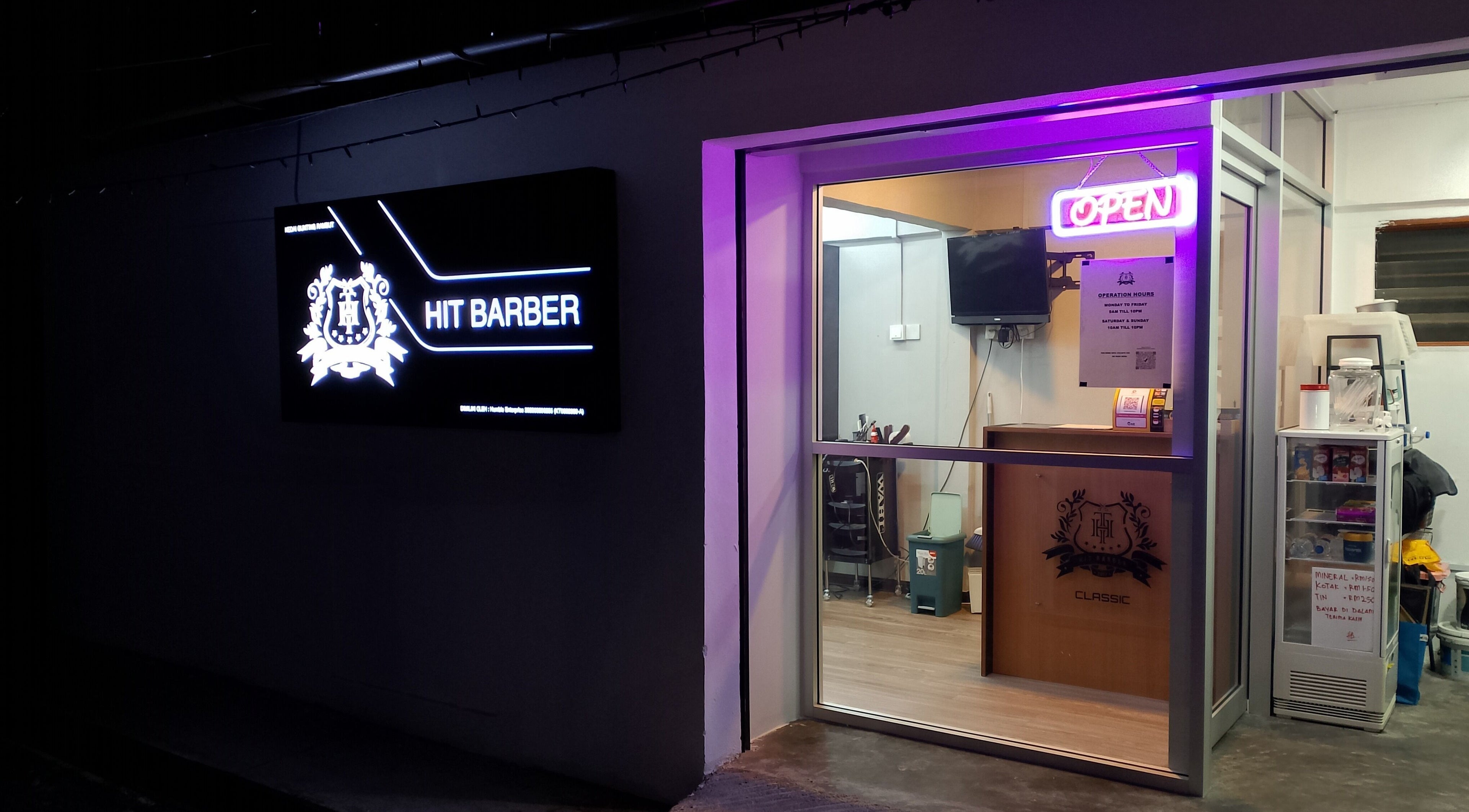 Entrance of Hit Barber Classic TTDI, Kuala Lumpur, showcasing neon signs and inviting interior.