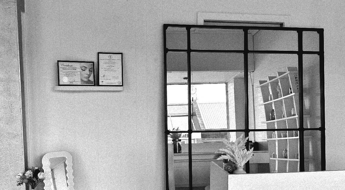 Elegant interior of Khai Beauty, Portland, NSW with decor and displayed certificates on a cozy wall shelf.