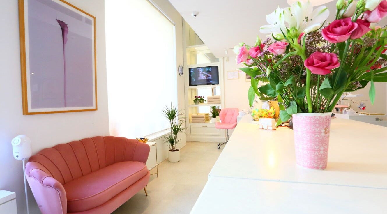 Sproščujoč ambient Studio Tri Krasne v Ljubljani z elegantnim rožnatim pohištvom in cvetličnimi aranžmaji.