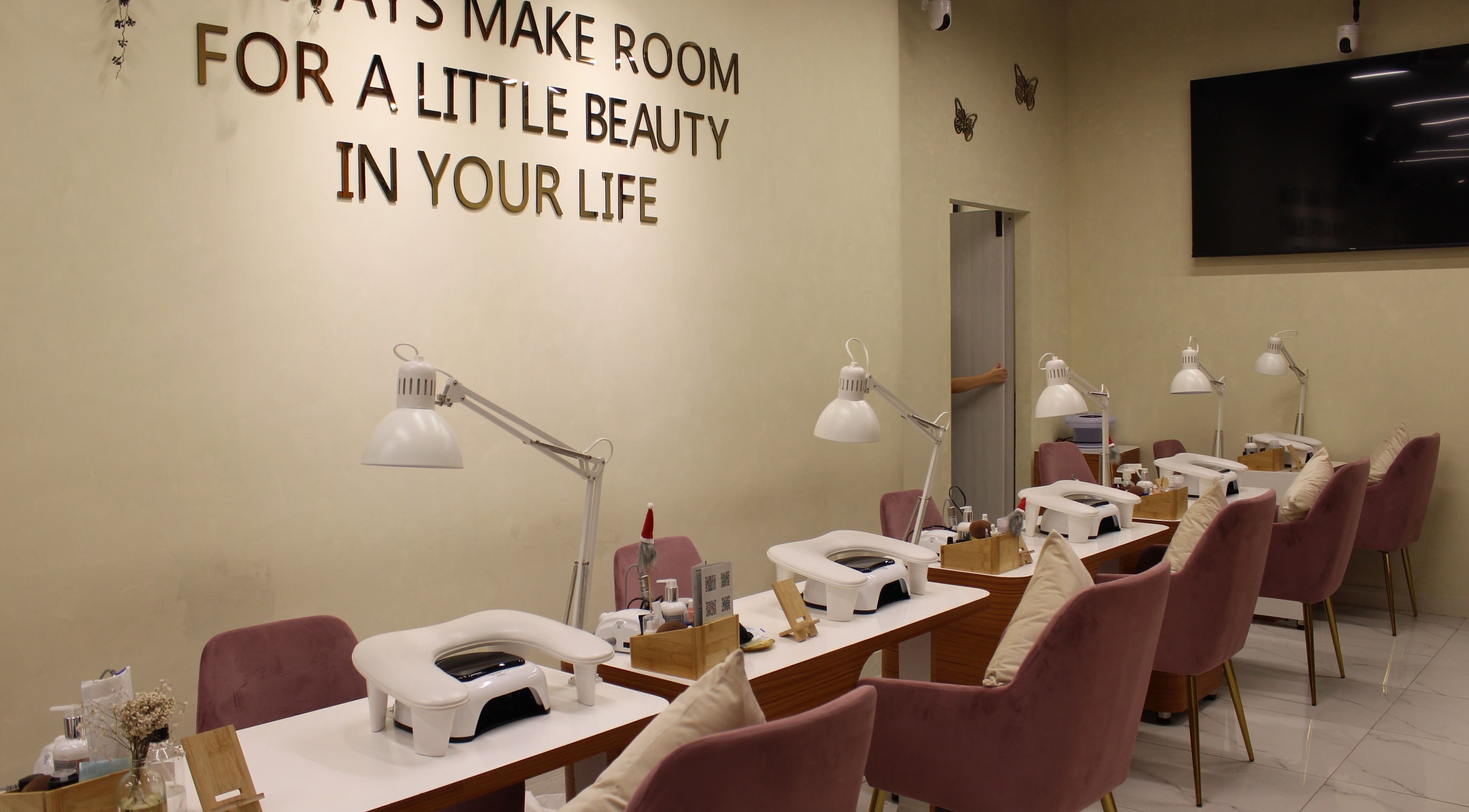 Manicure stations at Maison Des Femmes Beauty Salon, Dubai, Dubai, AE with elegant decor and plush chairs.