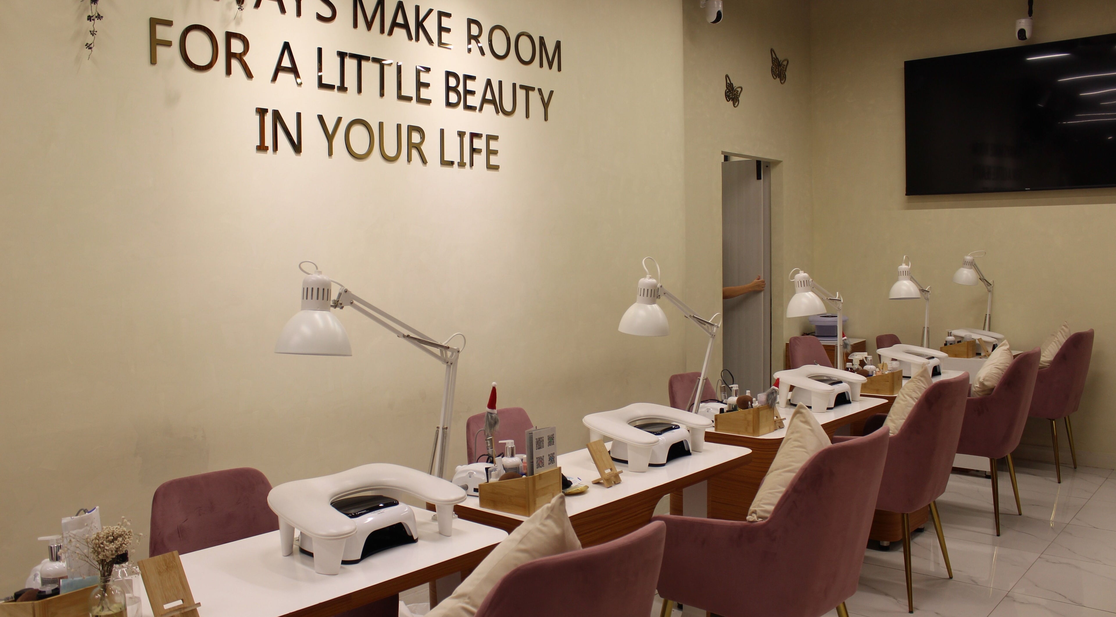 Manicure stations at Maison Des Femmes Beauty Salon, Dubai, Dubai, AE with elegant decor and plush chairs.