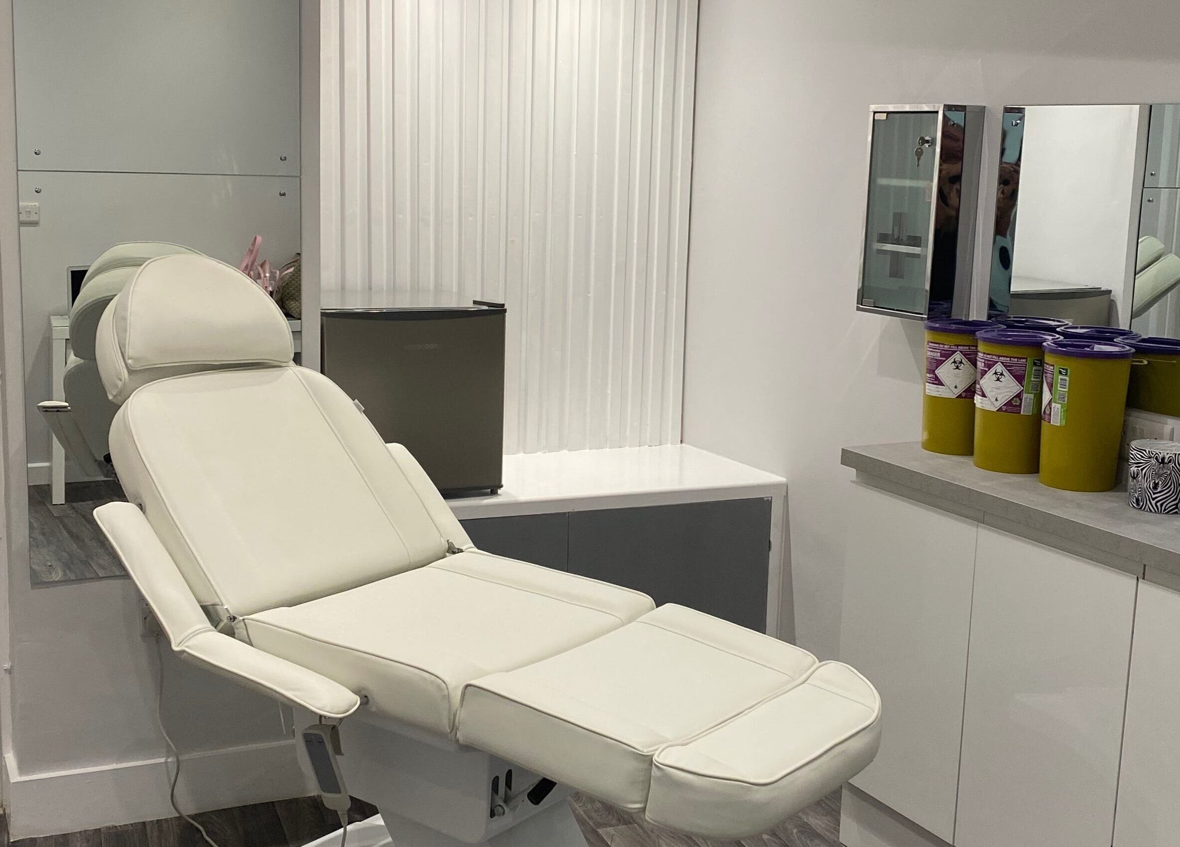 Modern treatment room at House of Boo, Petersfield, England with a sleek white chair and mirrors.