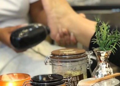 Foot massage at Studio Karla Horrana in Amsterdam, Noord-Holland, NL with candles and plants creating a serene ambiance.