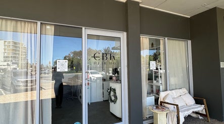 Isla hair salon entrance in Maroochydore, Queensland, AU, showcasing modern glass doors and a cozy seating area.