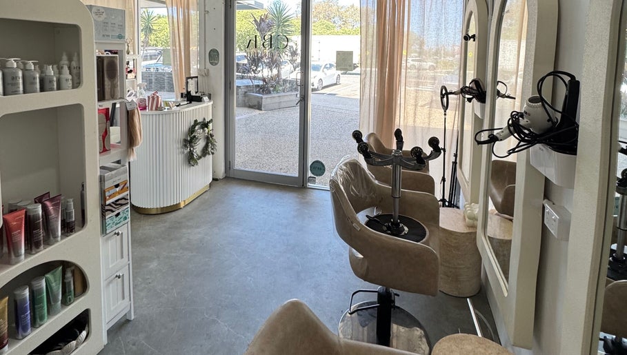 Modern Isla Hair salon interior in Maroochydore, Queensland, AU, with styling chairs and product display.